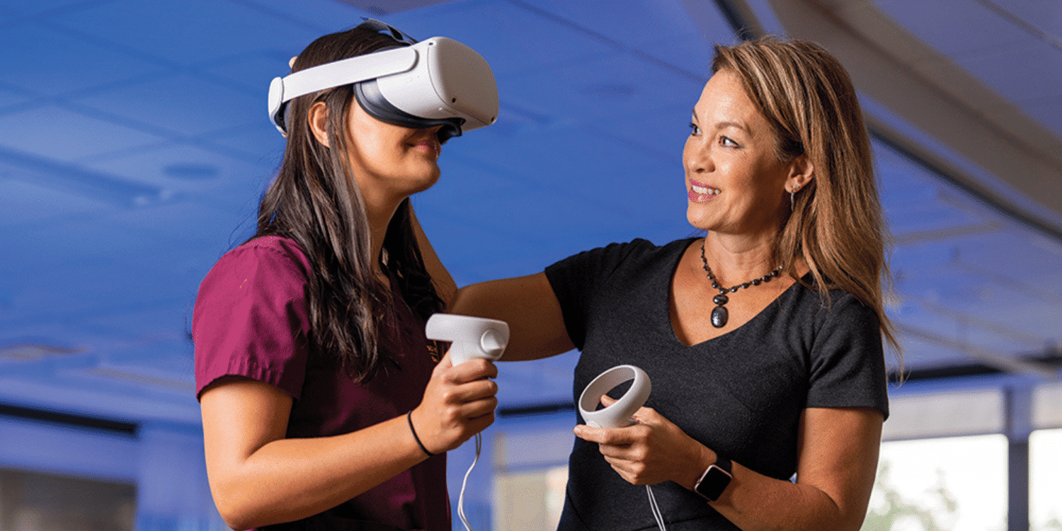 Faculty working with student in VR headset