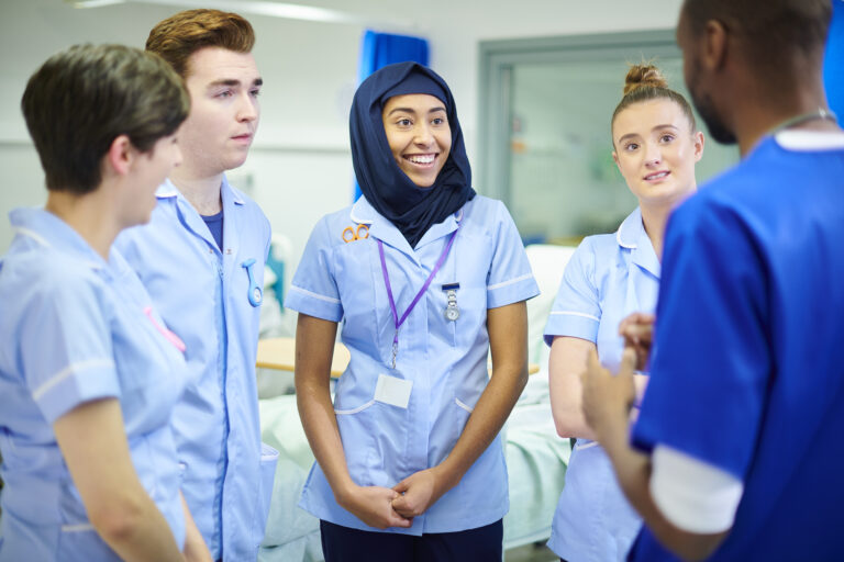 Four nursing students with talking with an educator