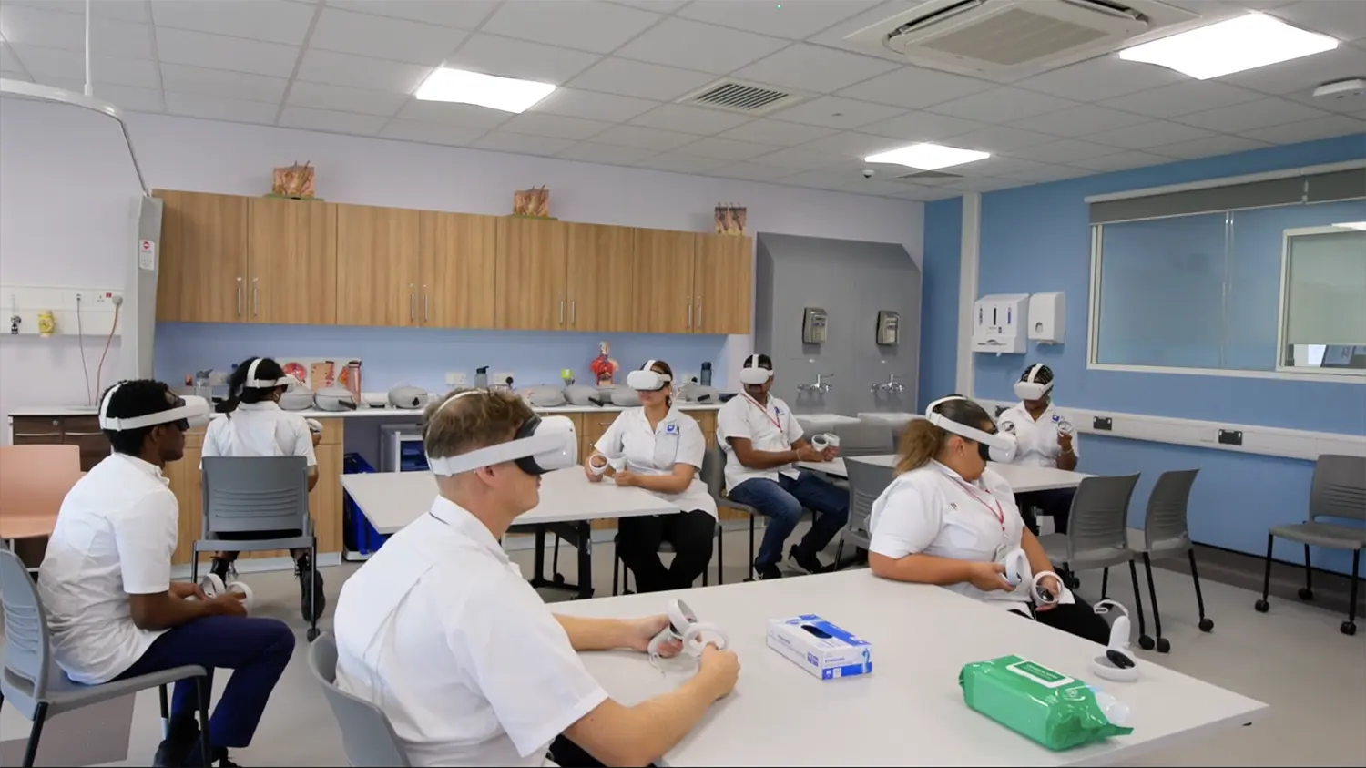 **Alt text:** Nursing students using VR headsets in clinical training classroom